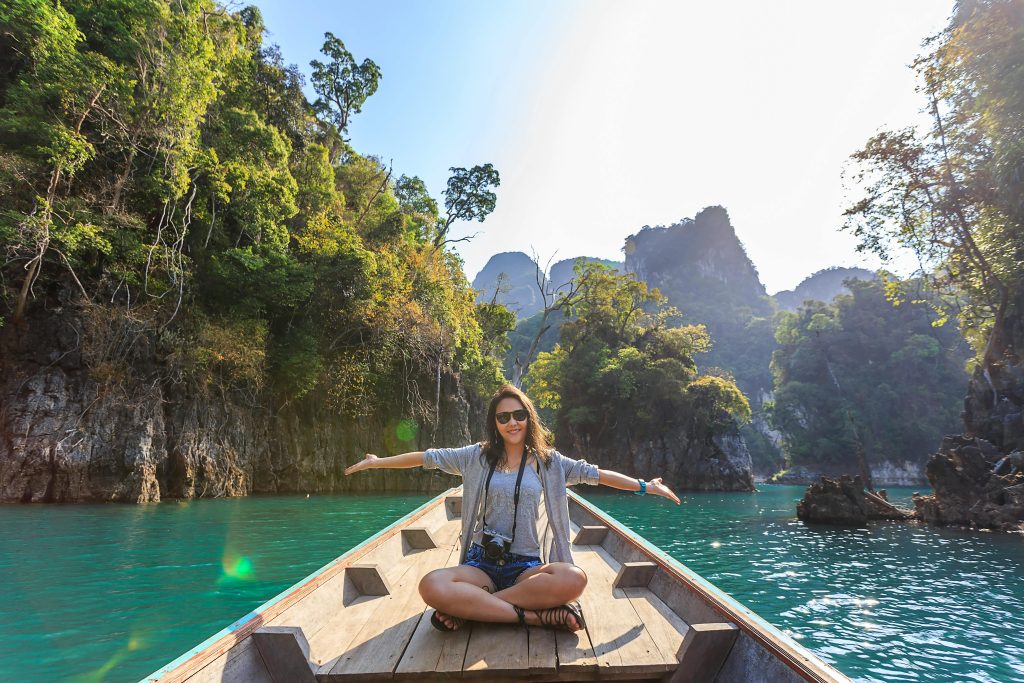 pexels-photo-1371360-1371360 Asian woman relishing a serene boat journey through the lush karst landscape of Thailand's Khlong Sok.